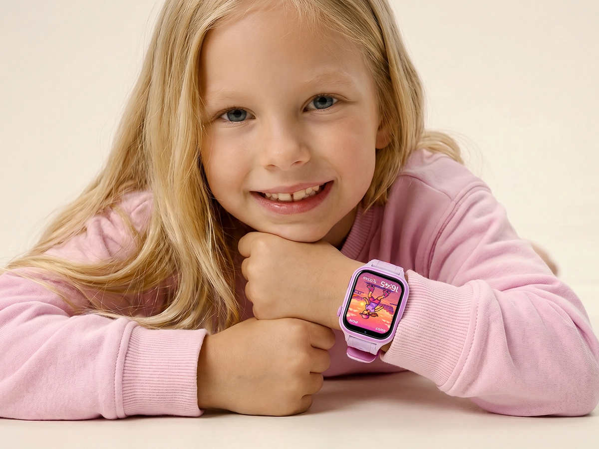 Dziewczynka w różowej bluzie prezentuje smartwatch dziecięcy Besti na nadgarstku.