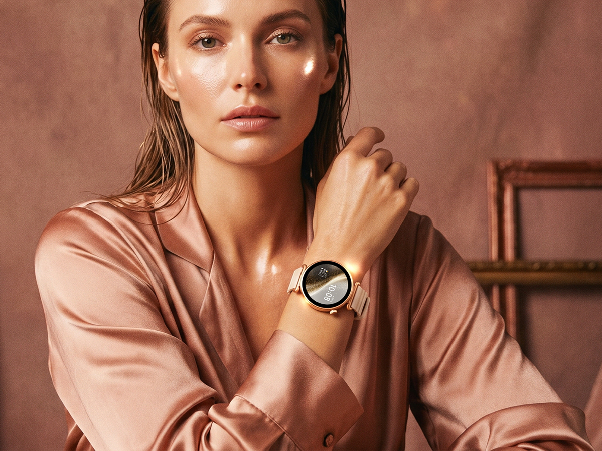 Kobieta w satynowej stylizacji prezentuje damski smartwatch Rosa Dust z motywem niebieskiego kwiatu.